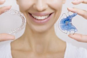 female girl with different types of retainers in hand