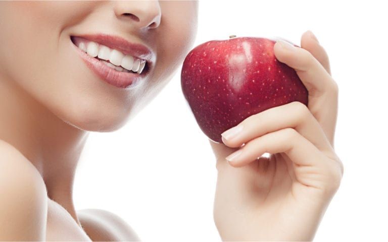 Woman smiling holding apple